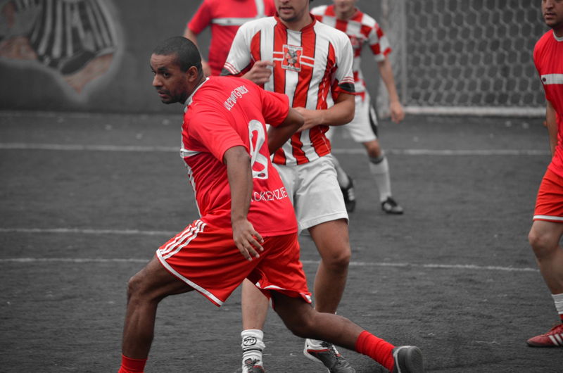 football game between two teams only red shows rest monochrome